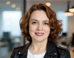 Professional headshot of Ana Olmedo, founder of Bravaura Consulting, wearing a blue blazer and smiling confidently